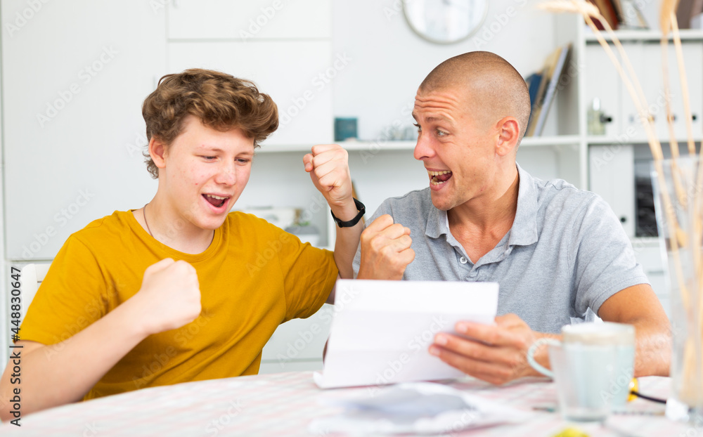 Fototapeta premium Happy son and father rejoice at the good news letter