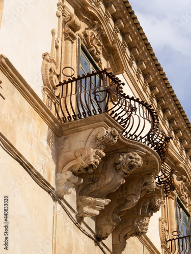 Grotesque faces with open mouth supporting a balcony of the Baroque Palazzo Beneventano, Scicli photo