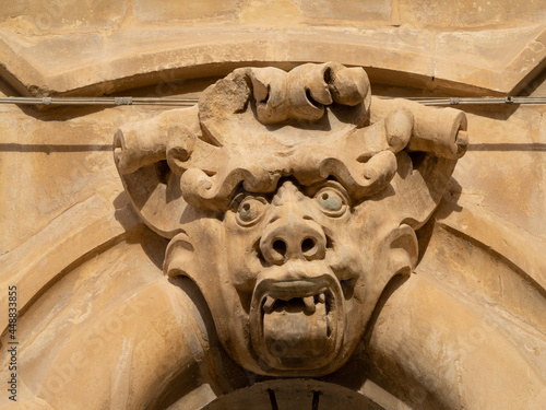 Human like grotesque face over a door of the Baroque Palazzo Beneventano, Scicli photo