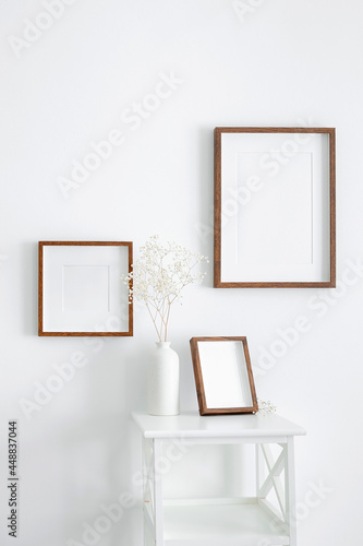 Frames mockup on white wall for photo or print presentation. Minimalistics style indoor interior with artwork mockup.