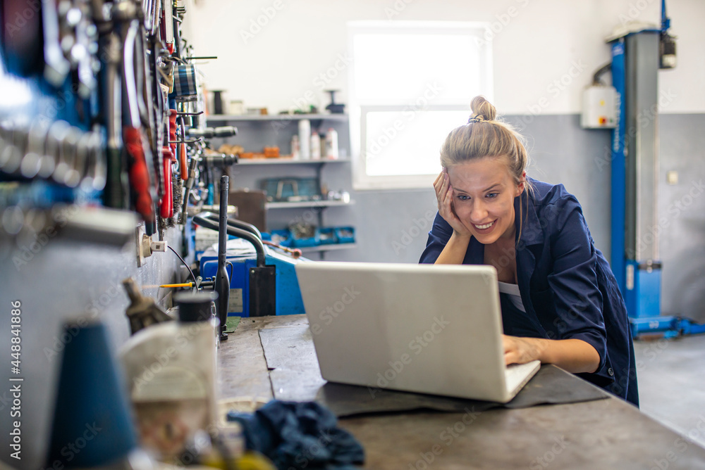 Business woman at a factory. Craftswoman working using a laptop in the garage. Mechanic using laptop at the repair garage. Young female mechanic with laptop. Business woman at a factory. Business woman at a factory. Craftswoman working using a laptop in the garage. Mechanic using laptop at the repair garage. Young female mechanic with laptop. Business woman at a factory.