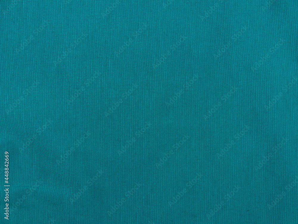 Turquoise jersey fabric matte texture top view. Blue knitwear background. Fashion color trendy clothes. Website backdrop