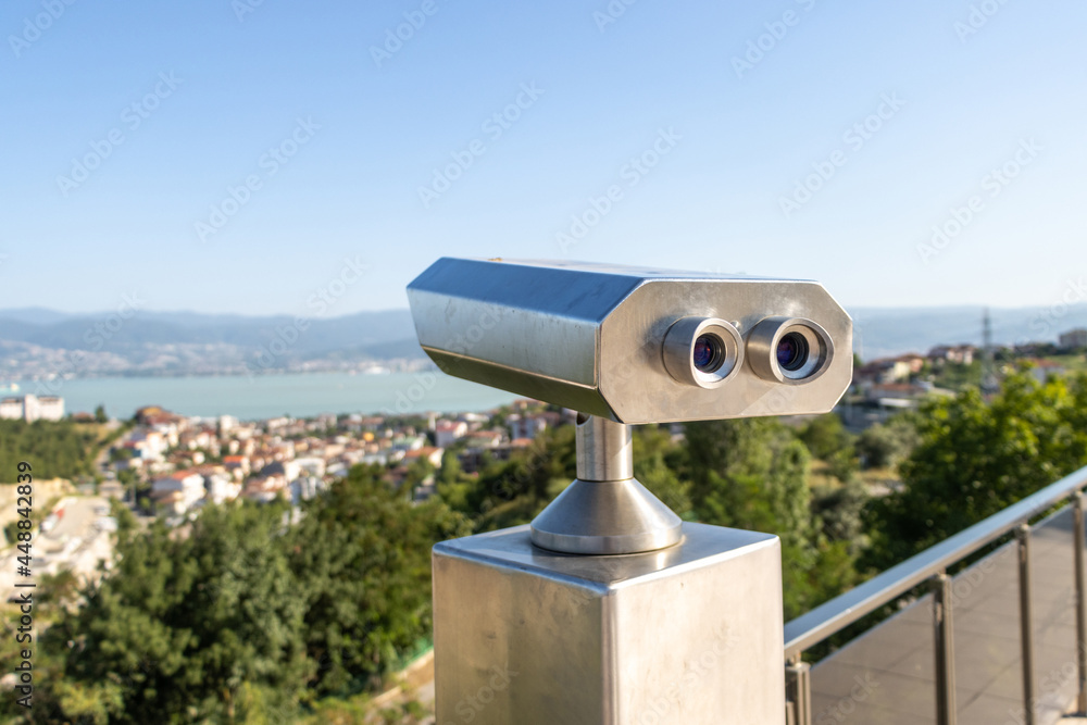 Touristic coin operated telescope binoculars look at the city landscape view