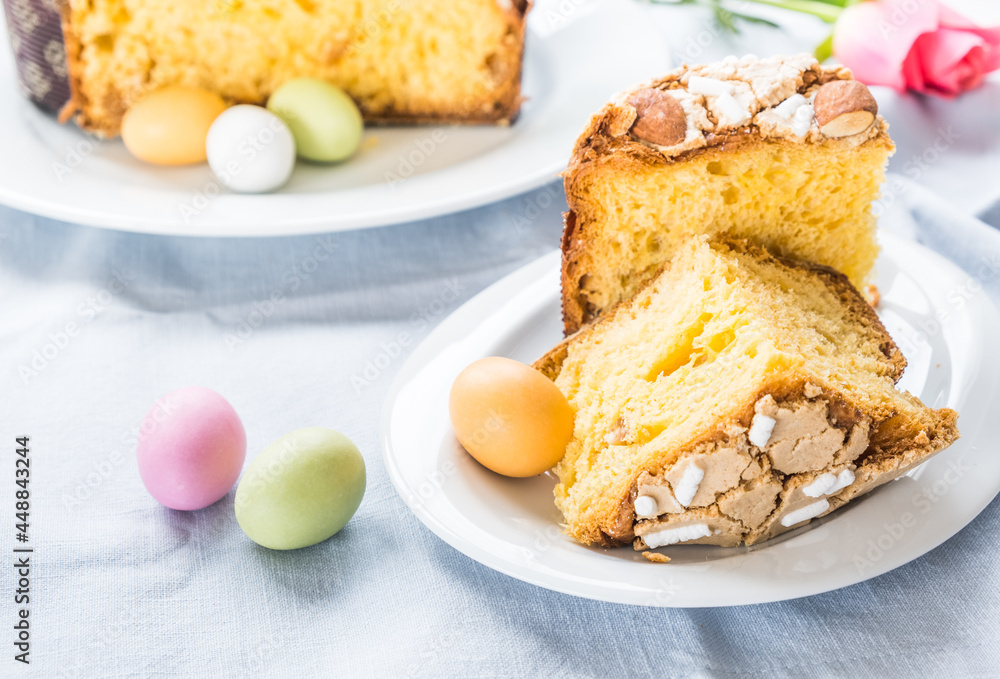 Piece of traditional italian Easter cake Colomba and Easter marzipan eggs in pastel colors, close up Piece of traditional italian Easter cake Colomba and Easter marzipan eggs in pastel colors, close up