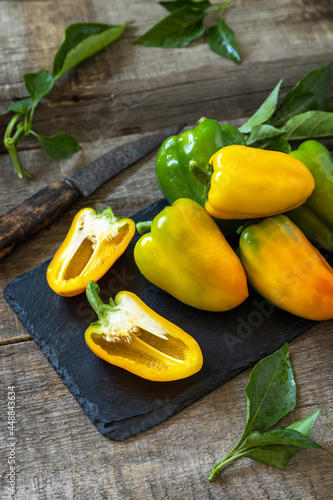 Organic healthy raw ripe sweet pepper, yellow paprika, on a kitchen wooden table. The concept of Diet menu and harvesting. Copy space.