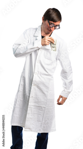 man in a white medical coat. funny doctor puts money in his pocket. bribes in medicine, paid medicine. isolated, white background