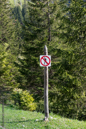 A no-walking sign in the tourist version showing a tourist with a backpack standing near the trail in the Tatra Mountains