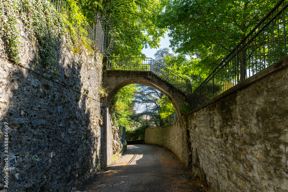 Small bridge with stairs, over a small road, in Brunate, Como, Lombardy, Italy. It is a very cute, small, old, rustic bridge, over a beautiful small road. It is a very beautiful sunny, summer day