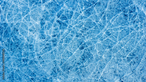 Beautiful ice texture with cracks of a frozen puddle on the asphalt for 3d texturing or design.