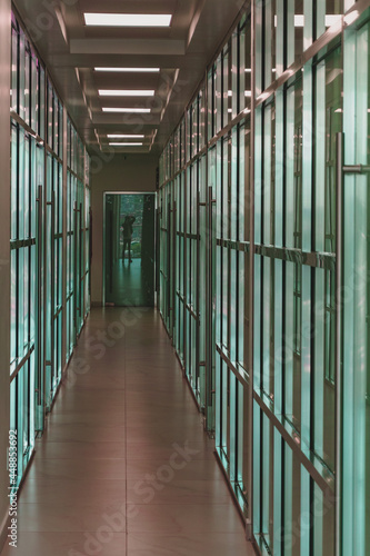 Wallpaper Mural Pasillo con vitrales de color azul y destaques plateados con el reflejo de una persona al final  Torontodigital.ca