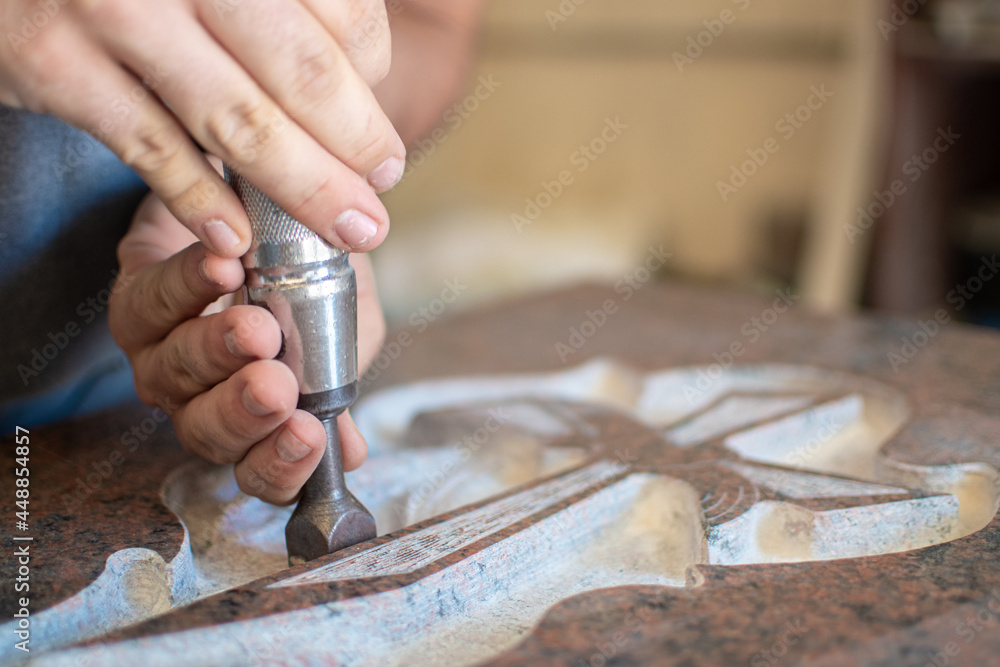 caucasian man hands bushhammered a tombstone in a workshop, work concept - obrazy, fototapety, plakaty 