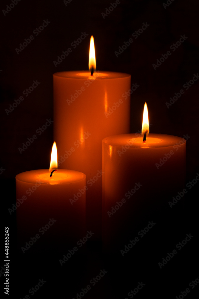 Three Pillar Candles Burning in a Dark Room Three Pillar Candles Burning in a Dark Room