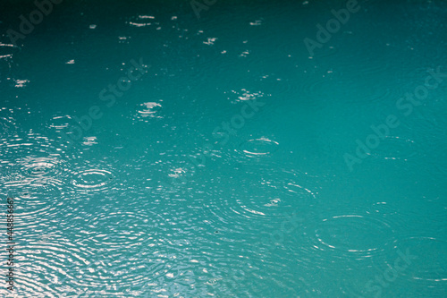 Rain drops in a turquoise pool