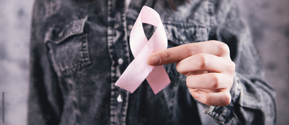 Fototapeta premium female hands holding a pink ribbon