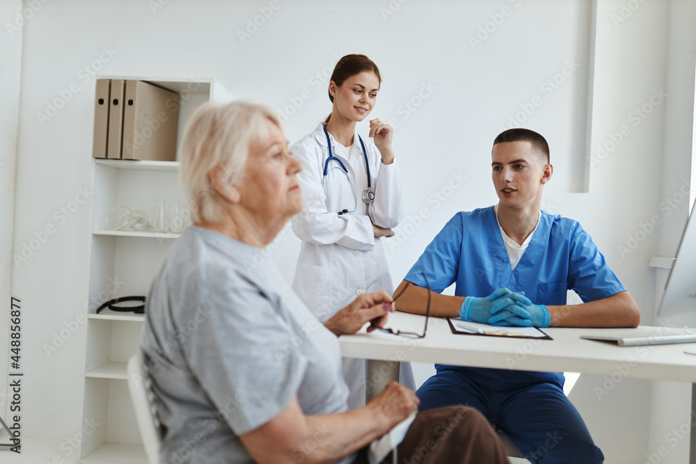 male doctor with a nurse examining an elderly woman health hospital male doctor with a nurse examining an elderly woman health hospital