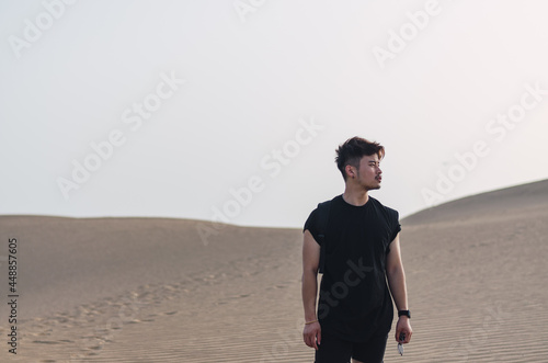 Portrait of young handsome Chinese tourist standing while admiring the sand dunes in Maspalomas © Rui Xu