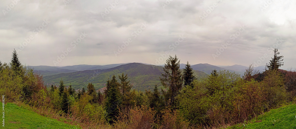 Beautiful landscape showing panoramic view from top of Wielki lubon hill top. Mountain and hill surrounded with green trees against dramatic clouds during rainy weather.located near rabka, Poland Beautiful landscape showing panoramic view from top of Wielki lubon hill top. Mountain and hill surrounded with green trees against dramatic clouds during rainy weather.located near rabka, Poland