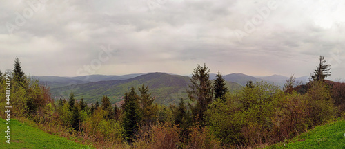 Beautiful landscape showing panoramic view from top of Wielki lubon hill top. Mountain and hill surrounded with green trees against dramatic clouds during rainy weather.located near rabka, Poland