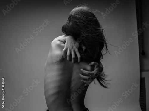 woman with red hair hands on back back view black and white photo