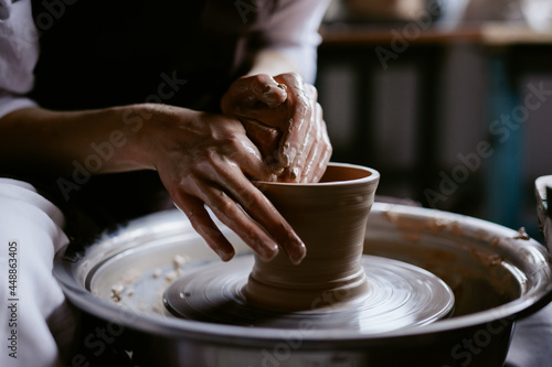 Crafter creating pottery on throwing wheel 