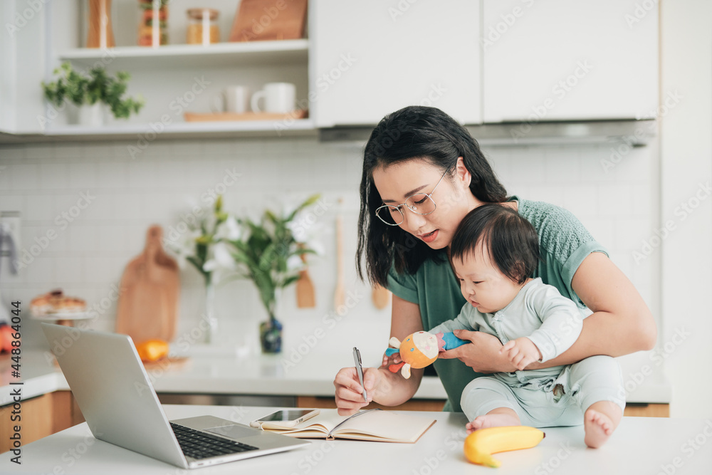 Female freelancer at dining table with adorable infant daughter Female freelancer at dining table with adorable infant daughter