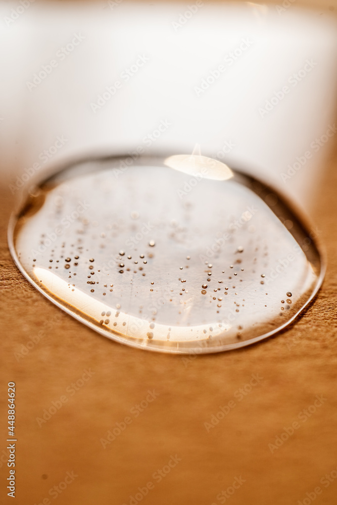 A drop of cosmetic gel on a beige background. A drop of cosmetic gel on a beige background.