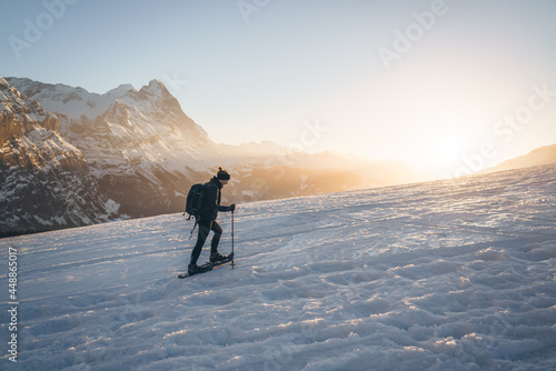 Girl on snowshoe ascent in nature of the alps mountains photo