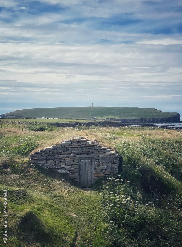 Fisherman Hut at Skiba Geo with Brough of Birsay in the distance. - obrazy, fototapety, plakaty 