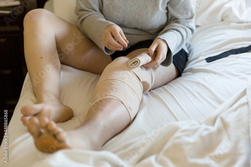 Woman wraps bandage around leg