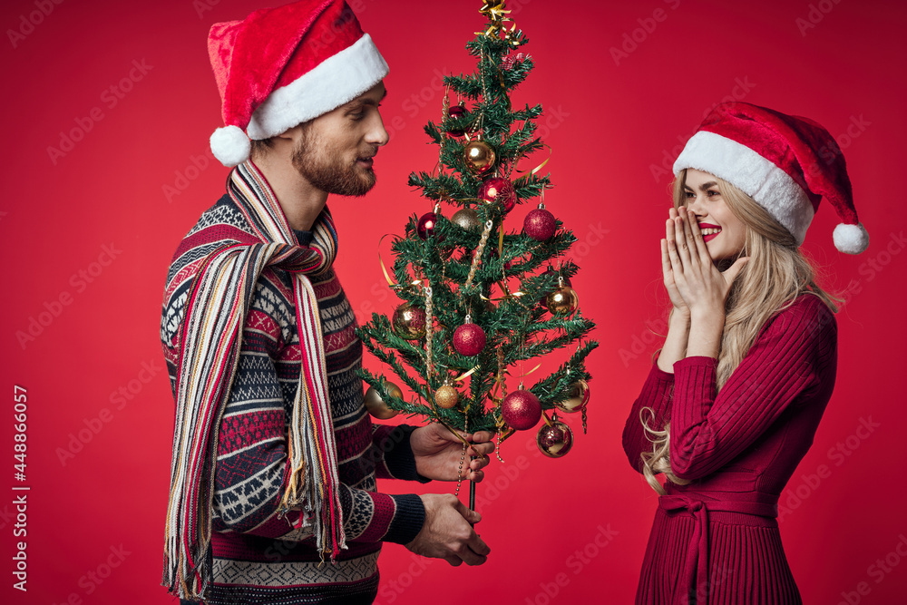 man and woman christmas tree decoration fun holiday red background man and woman christmas tree decoration fun holiday red background