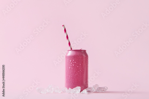 Pink can with paper straw and ice cubes photo