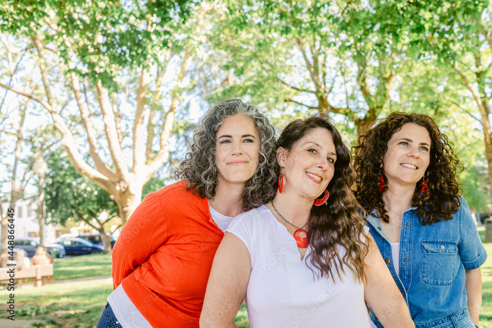Group of women hugging in park Group of women hugging in park