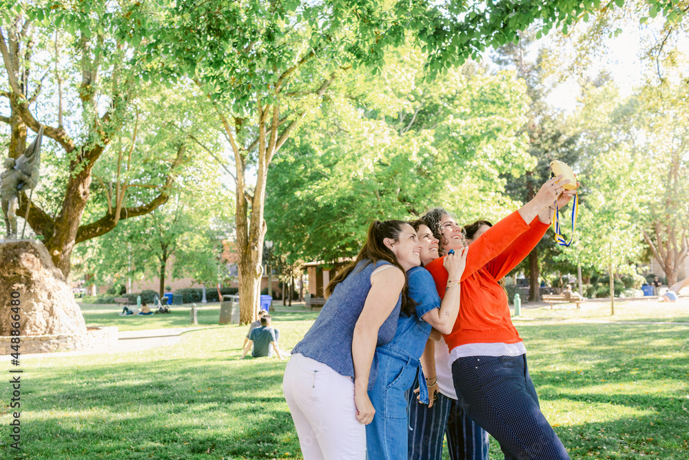 Happy girlfriends taking selfie on photo camera in park Happy girlfriends taking selfie on photo camera in park
