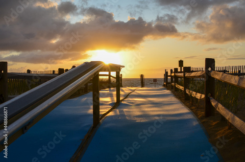 Accessible beach mats on walkway to Cape Cod beach. Sunrise Ocean Beach view.