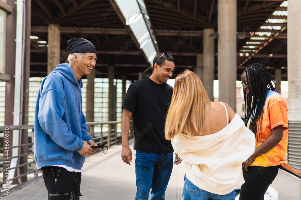 Diverse young friends resting in city together Diverse young friends resting in city together