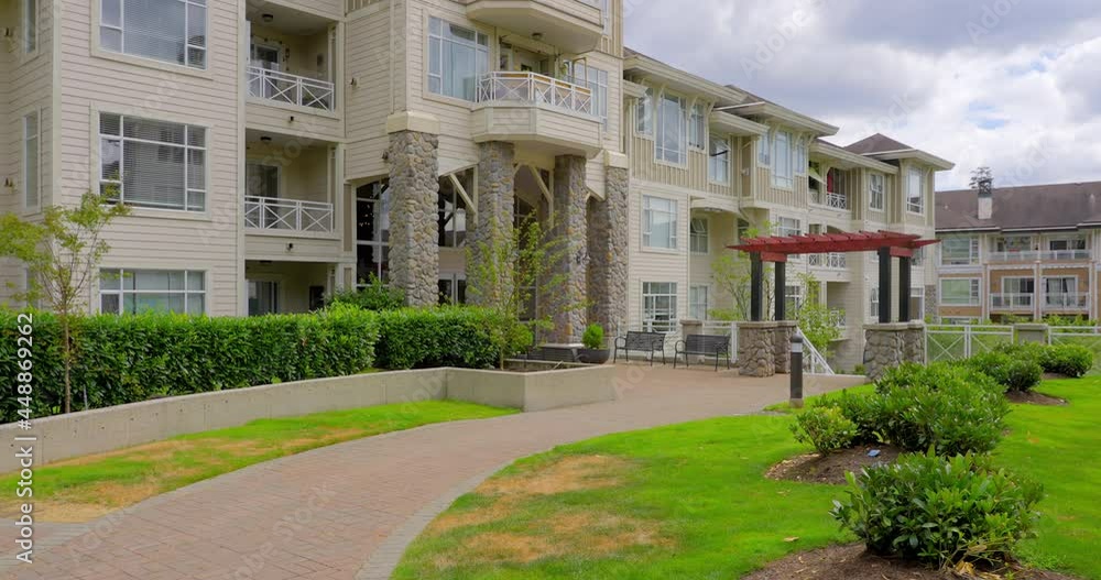Establishing shot of modern apartment building with balcony, trees and beautiful landscape in Vancouver, Canada, North America. Day time on July 2021. ProRes 422 HQ. Establishing shot of modern apartment building with balcony, trees and beautiful landscape in Vancouver, Canada, North America. Day time on July 2021. ProRes 422 HQ.