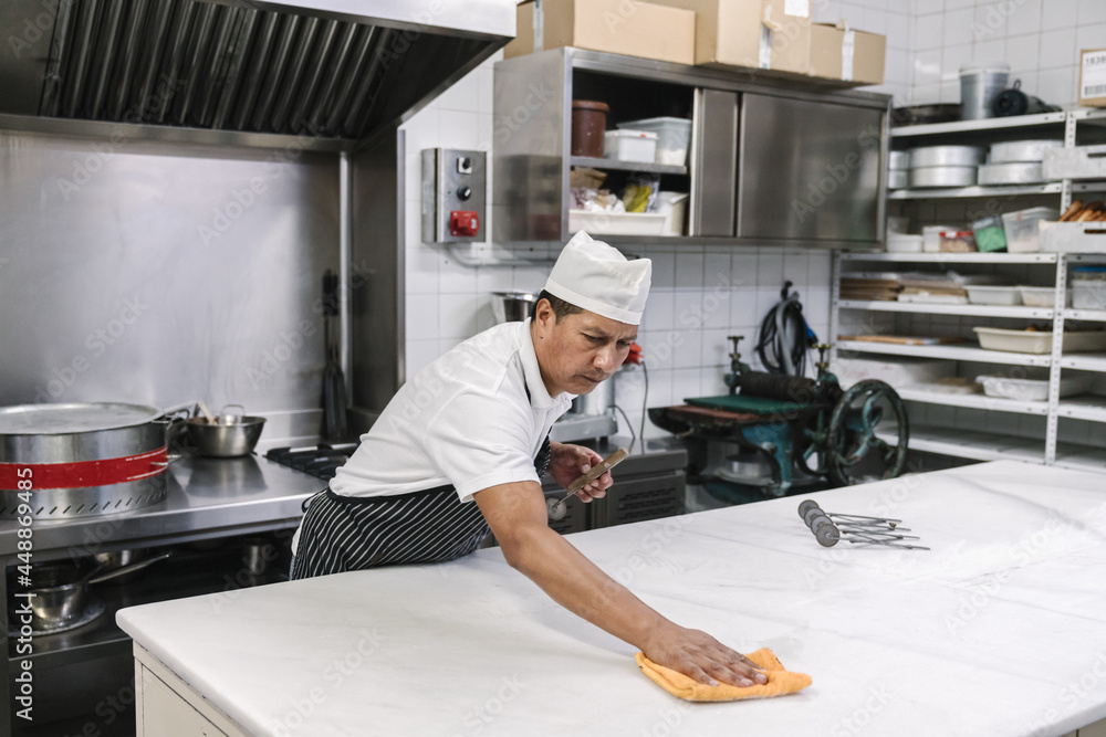 Man Cleaning His Workplace At Bakery Man Cleaning His Workplace At Bakery