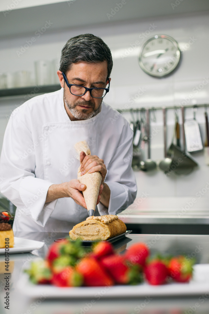Chef decorating cakes with pastry bag in hands Chef decorating cakes with pastry bag in hands