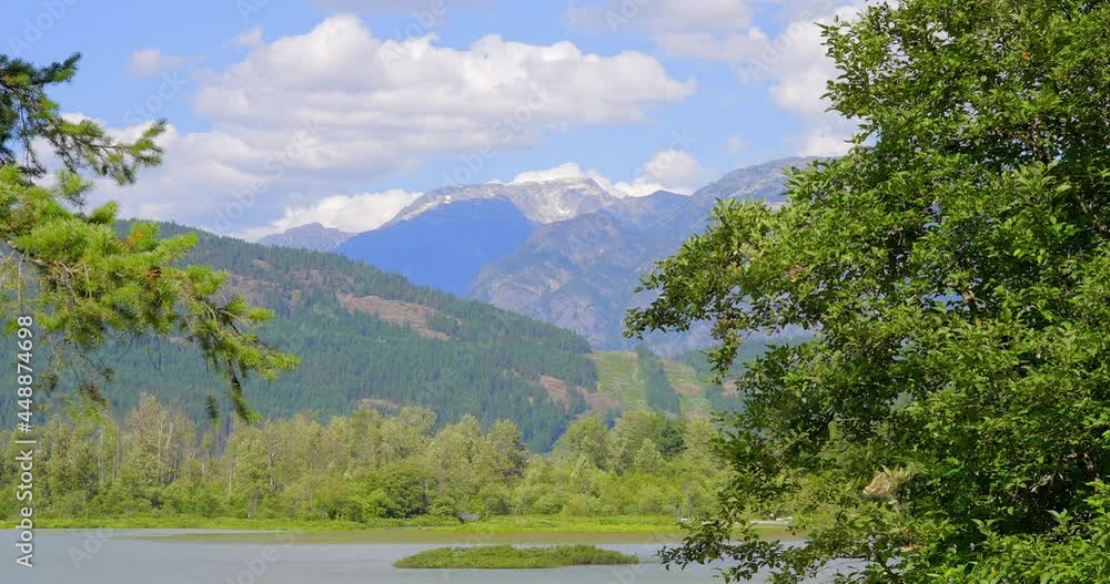 Establishing shot of majestic mountains with forest foreground in Vancouver, Canada, North America. Day time on July 2021. Still camera view. ProRes 422 HQ. Establishing shot of majestic mountains with forest foreground in Vancouver, Canada, North America. Day time on July 2021. Still camera view. ProRes 422 HQ.