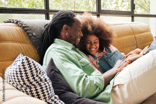 Father and daughter enjoy reading book  photo