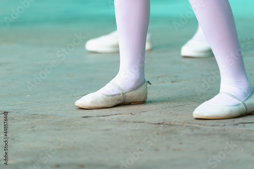White tights and ballet shoes on the leg.