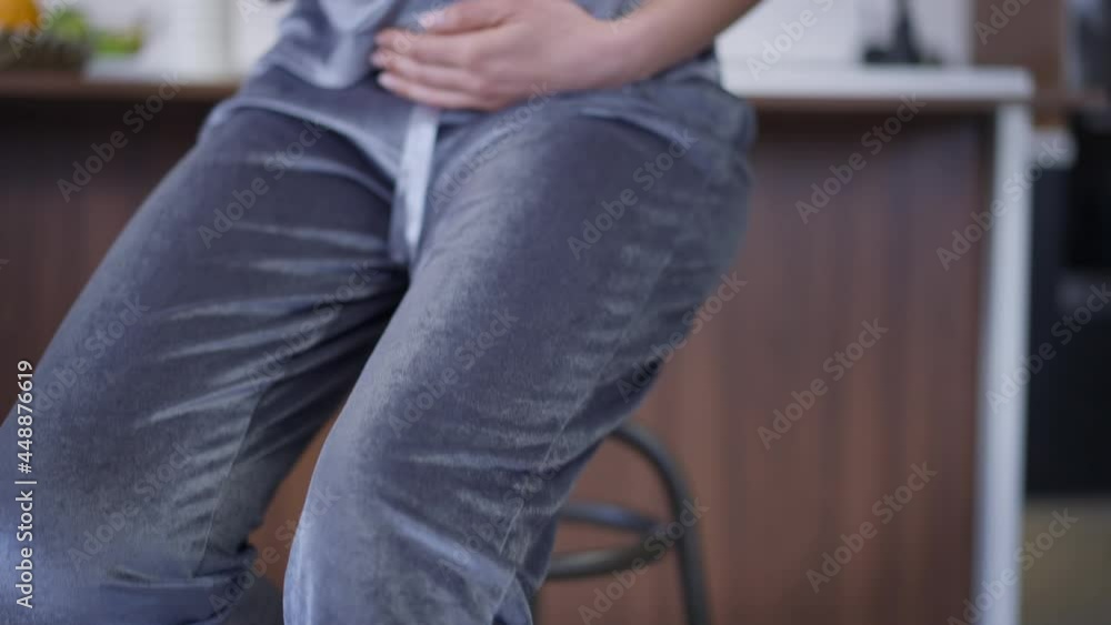 Live camera moves up from high-heels on feet to face of happy confident pregnant woman stroking belly sitting in kitchen at home. Calm Caucasian beautiful expectant posing indoors looking at camera Live camera moves up from high-heels on feet to face of happy confident pregnant woman stroking belly sitting in kitchen at home. Calm Caucasian beautiful expectant posing indoors looking at camera