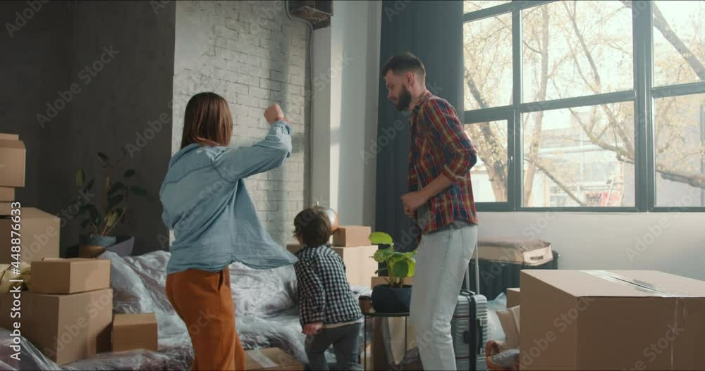 Excited happy fun young family with two kids dance together after unpacking celebrating buying, moving in new apartment. Excited happy fun young family with two kids dance together after unpacking celebrating buying, moving in new apartment.