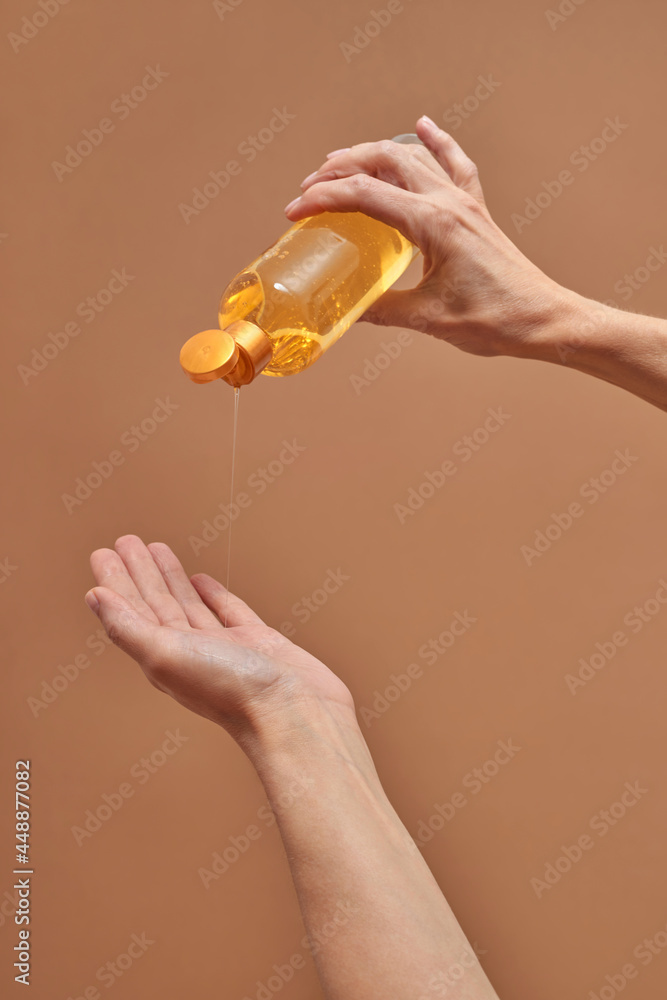 Anonymous female pouring gel on hand Anonymous female pouring gel on hand