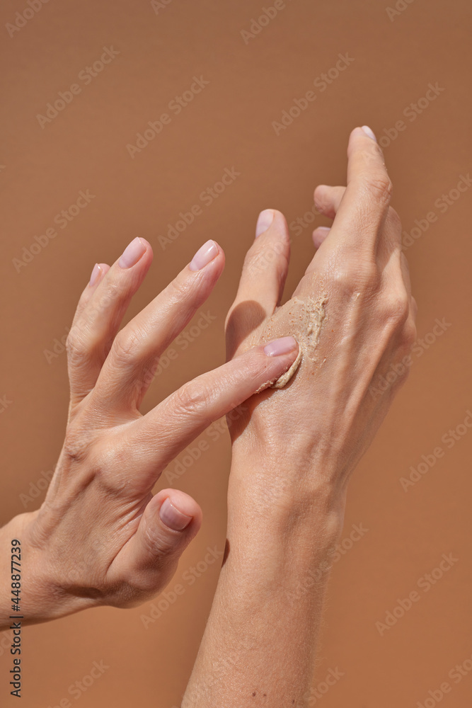 Unrecognizable female smearing scrub on hand Unrecognizable female smearing scrub on hand
