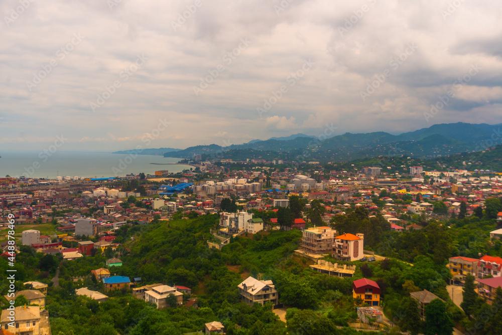 BATUMI, GEORGIA: Top view of the city from the cable car. Panorama of city buildings and mountains in the background.