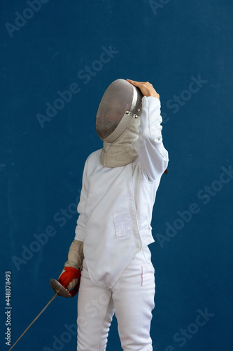 Unrecognizable fencer adjusting helmet during training photo