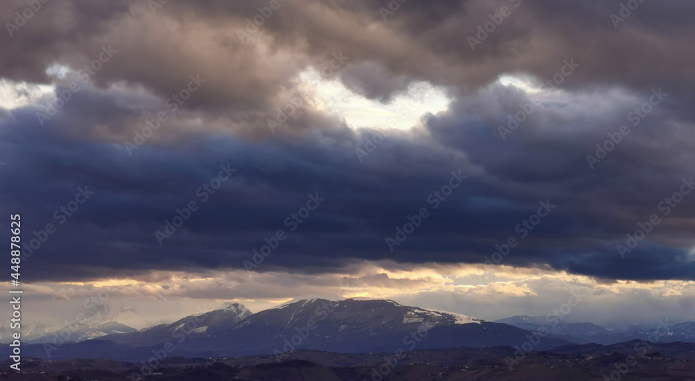 Enormi nuvole grigio azzurre sopra le montagne e le valli dell’Appennino