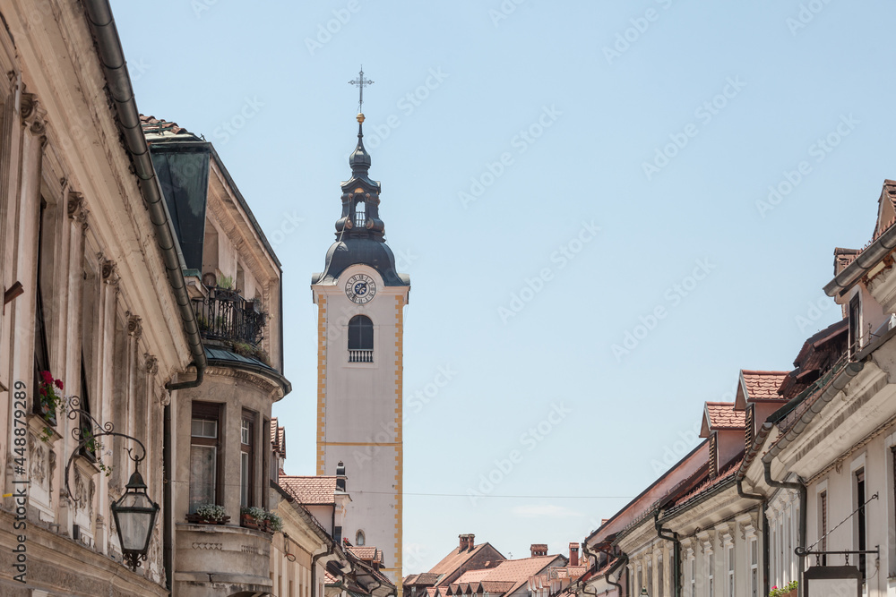 Church tower, cerkveni stolp, on the Zupinjska cerkev, a baroque roman catholic church in the center of Kamnik, Slovenia, on the main street of the city, Sutna, in a sunny summer afternoon...