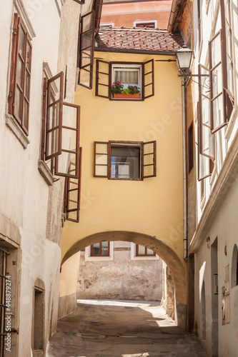 Empty picturesque medieval narow street with a bridge house over an arcade in the historical center of Skofja Loka  in Slovenia  in a district dating back from the middle ages...